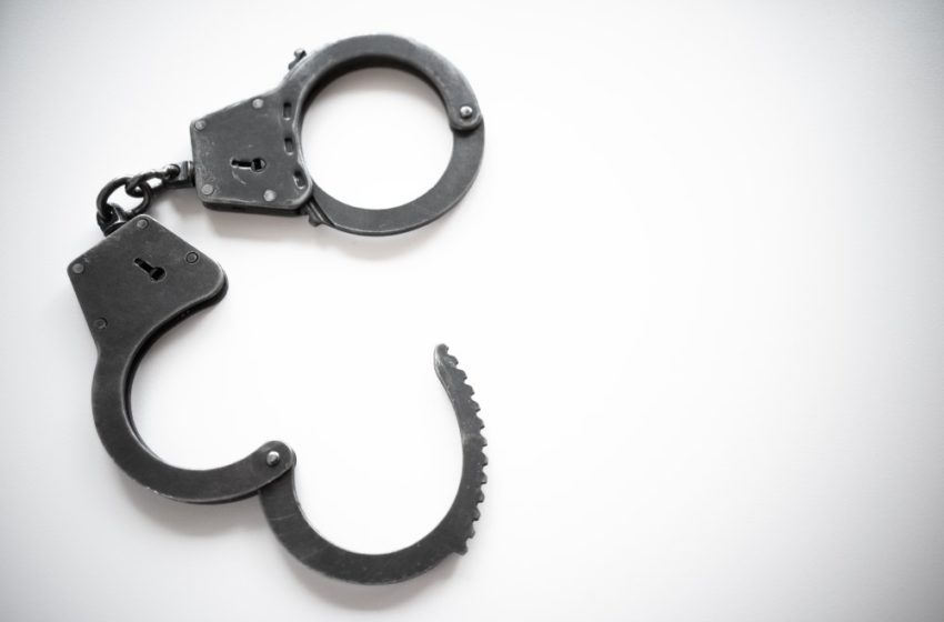 Handcuffs on a white background with the bottom cuff open