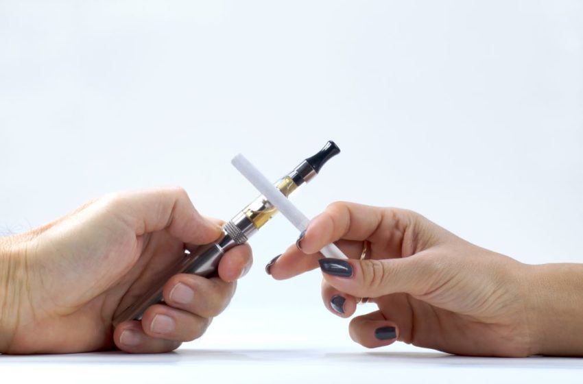 A man's hand with a cigarette and a woman's hand holding an e-cigarette